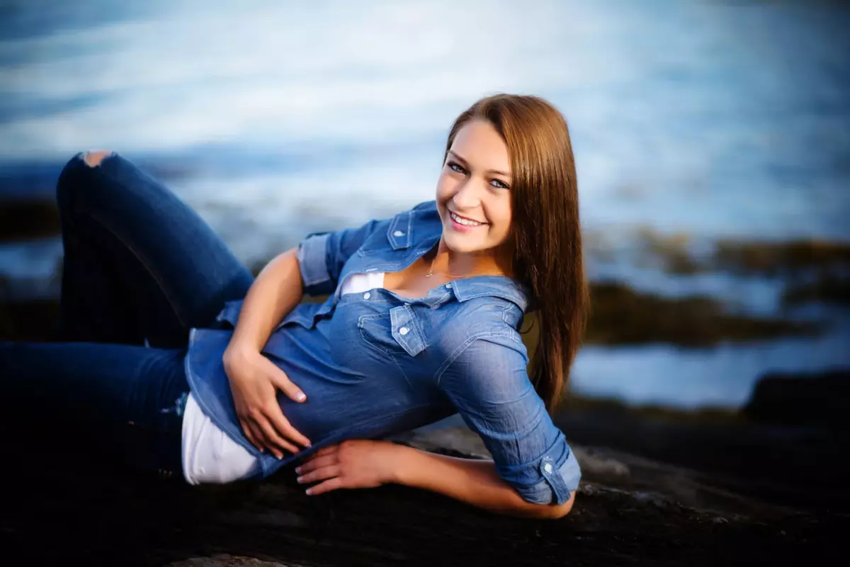 senior pictures at the beach in maine photo of girl in denim shirt on elbos
