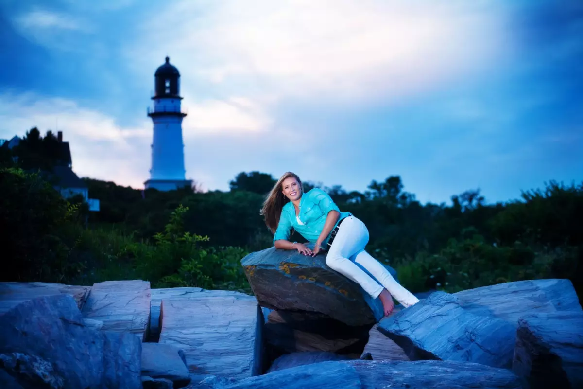 senior pictures at the beach in maine with lighthouse and sunset sky