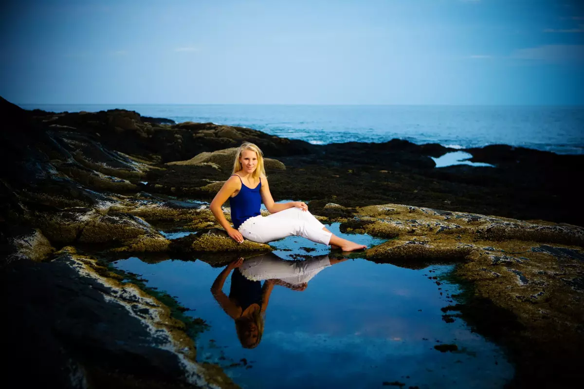 senior pictures at the beach on rocks with sunset in maine