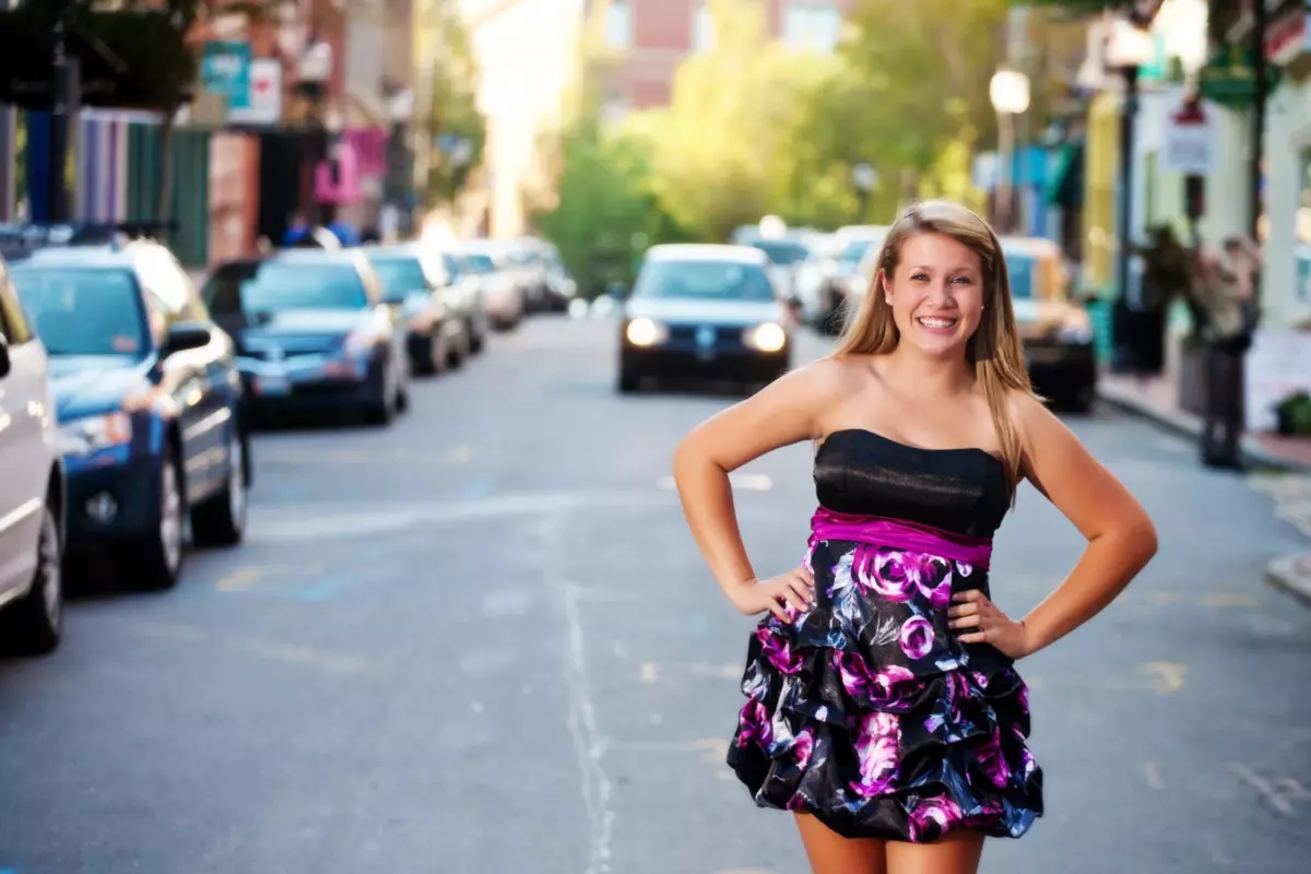 senior pictures of girl in colorful dress standing in exchange street with car oncoming in portland maine
