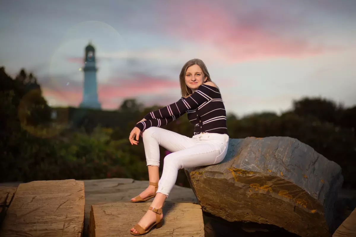 senior portraits photographed at the beach at sunset with maine lighthouse