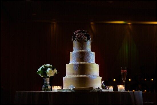 Elegant wedding cake with flowers and candles on table. Ideal for Maine weddings. Captured by professional wedding photographer. Maine photography. 