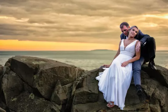 wedding couple at sunset on rocks at beach