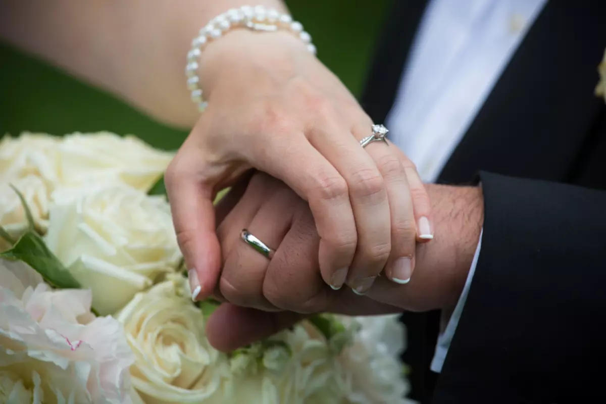 Wedding rings hands flowers