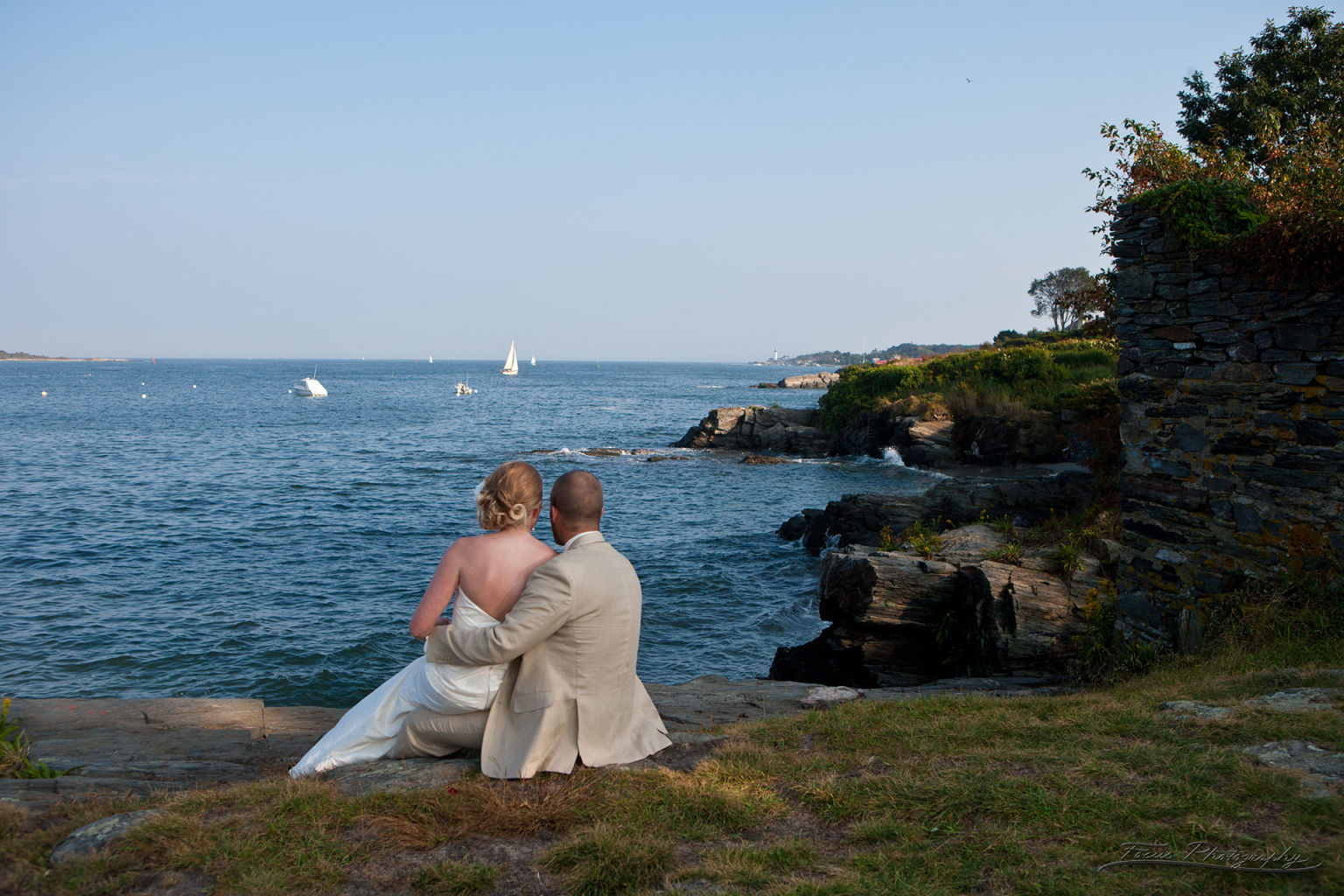 Bride and groom looking out at Maine ocean