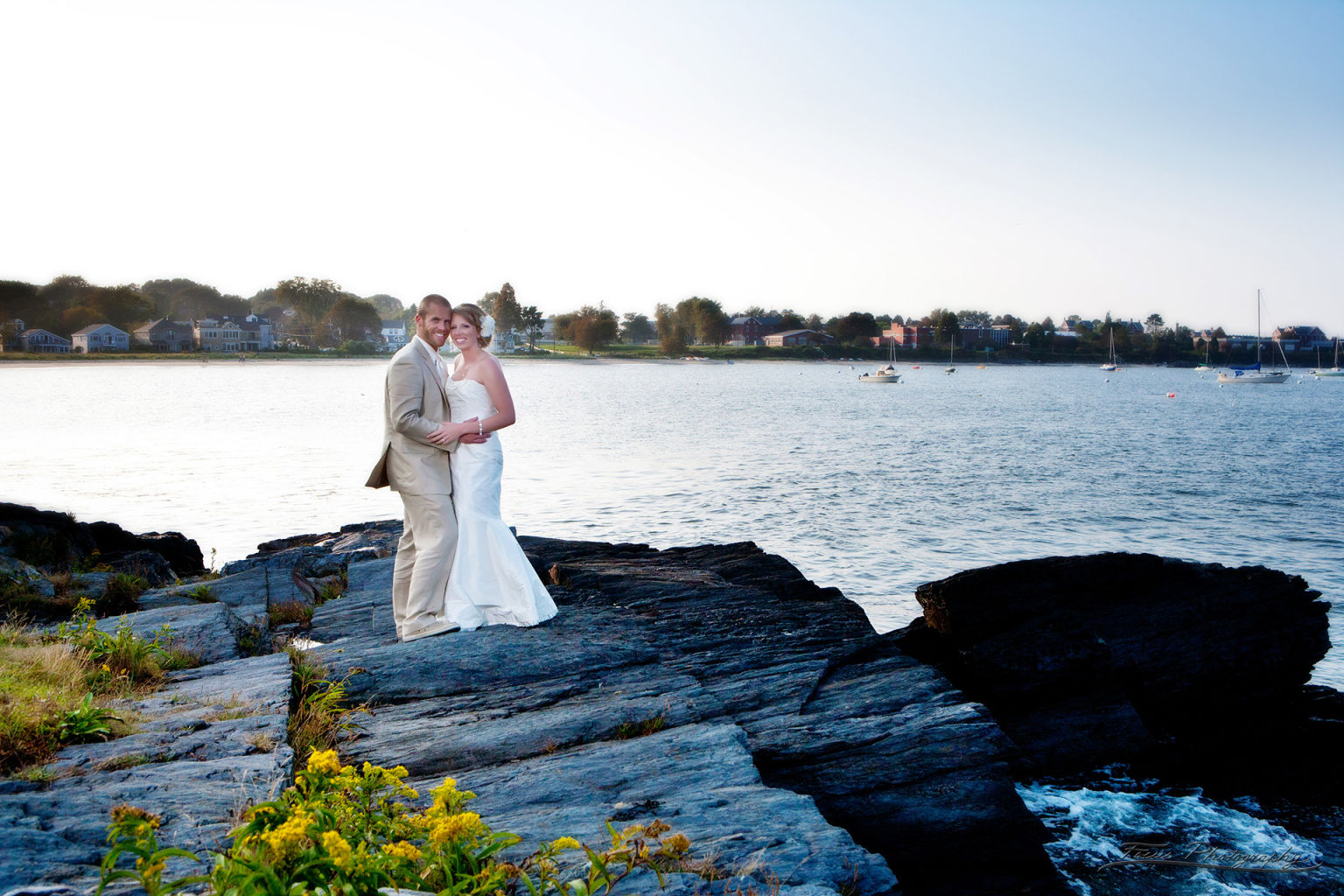 Bride and groom on rocks at Casco Bay Maine
