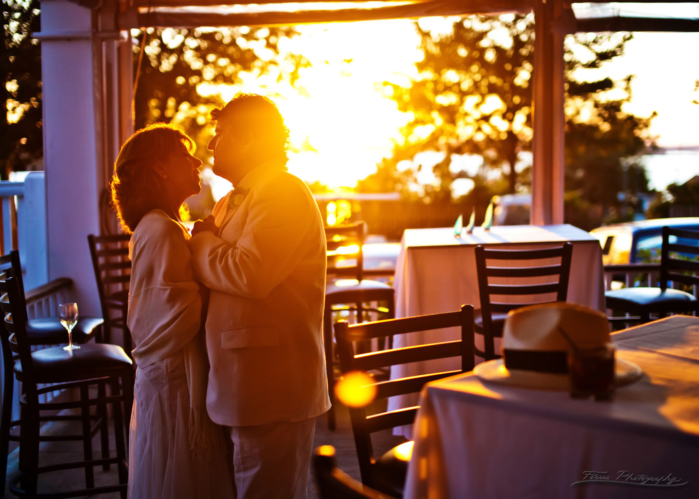 Bride and groom embracing each other at reception with sunset