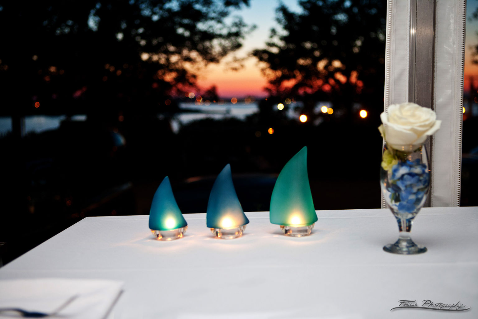 Blue and green decorations at Maine wedding with sunset