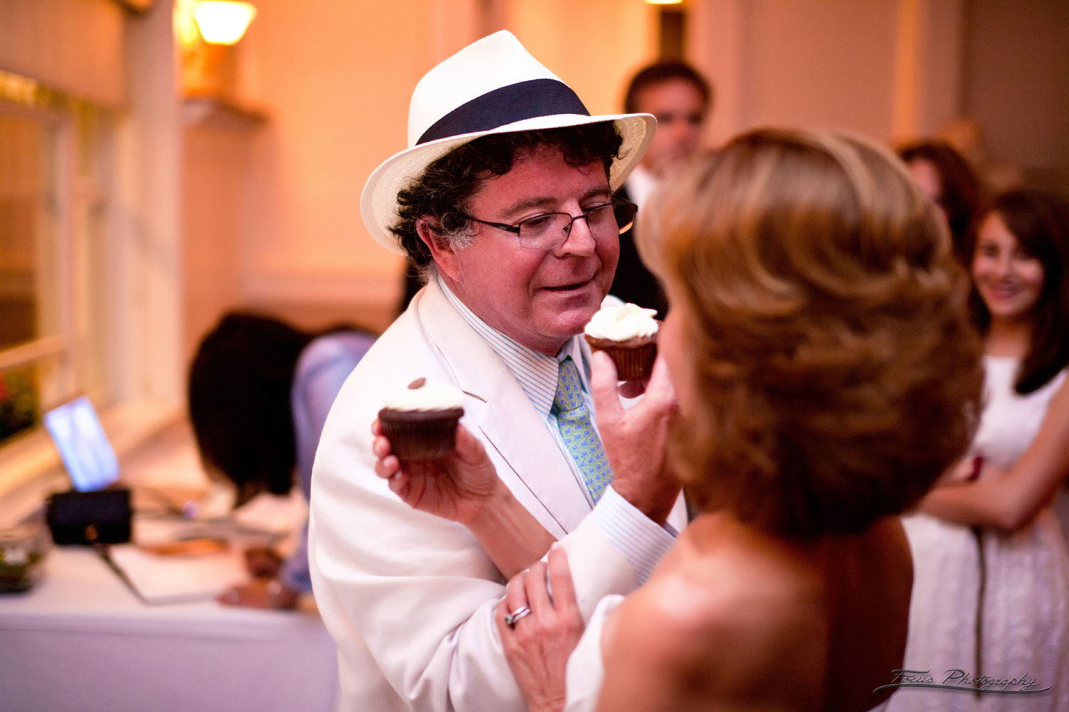 Bride and groom feeding each other cupcakes