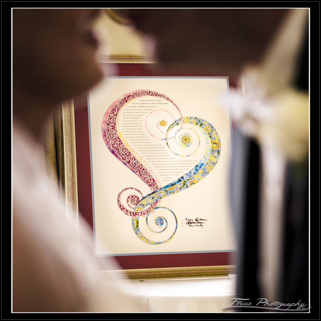 Ketubah (Jewish wedding contract) behind bride and groom at Wentworth wedding - photography by Focus