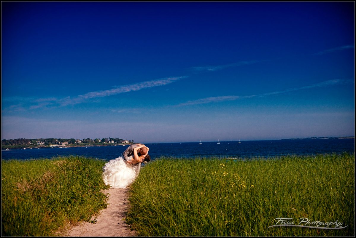 wedding couple dips in the dunegrass of Pine Point Beach in Scarborough, Maine
