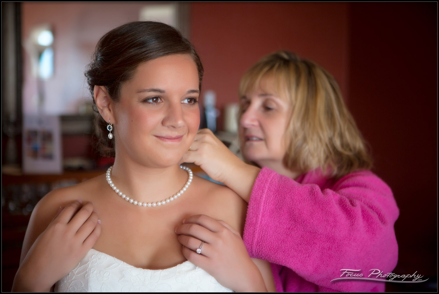 mother puts pearls on daughter