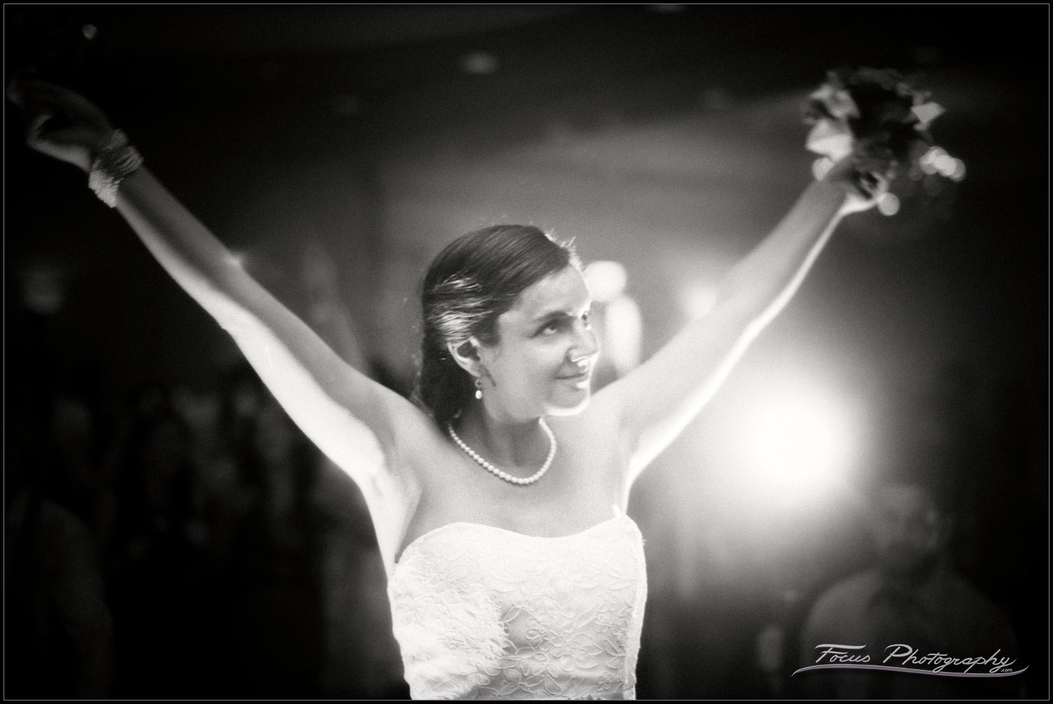 bride holds flowers in victory stance
