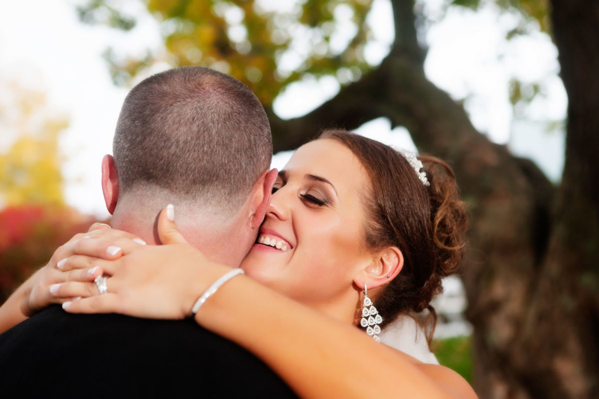 Red Barn Wedding, bride smiling while holding groom around the neck