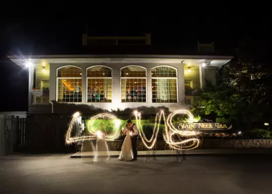 The bride and groom at a Stage Neck Inn wedding wrote the letters LOVE with sparklers in a long-exposure image.