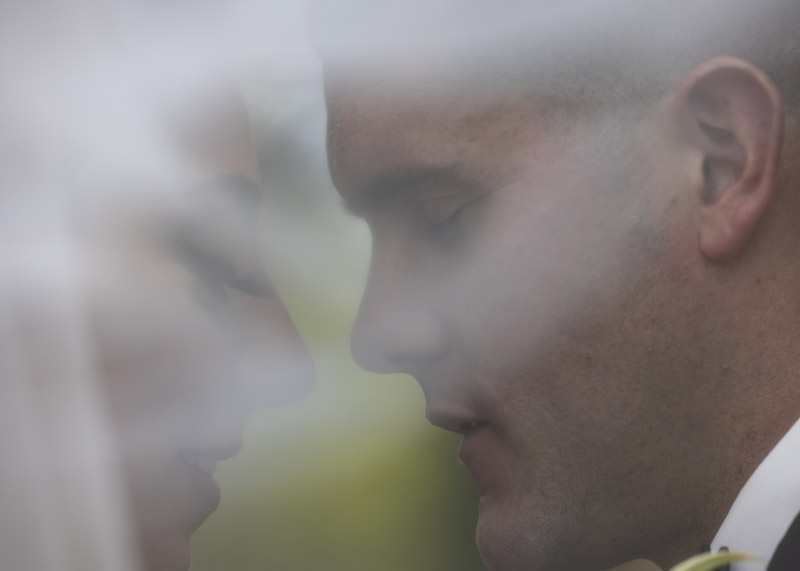 wedding portait of bride and groom inside the veil