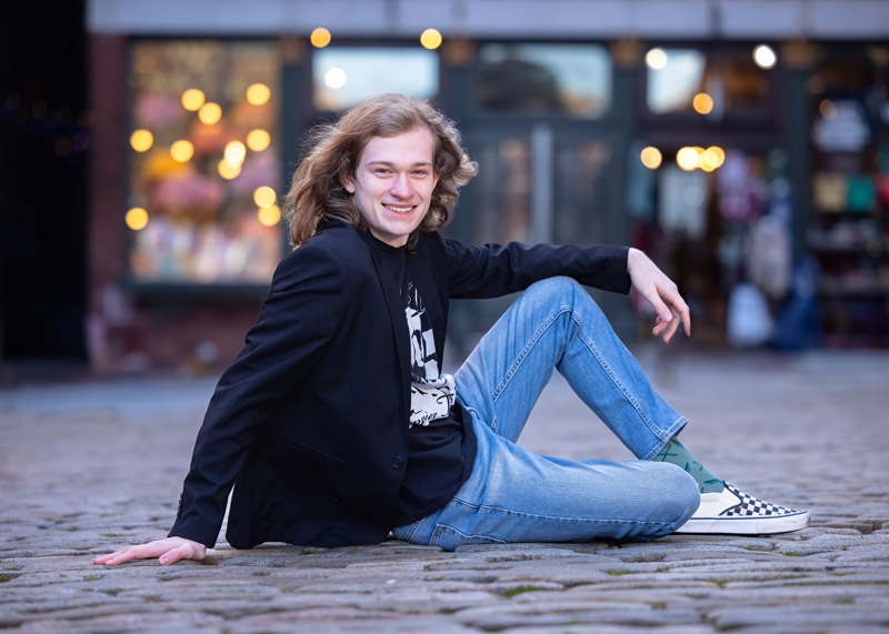 senior high school boy on the cobblestones of downtown Portland Maine for yearbook pictures