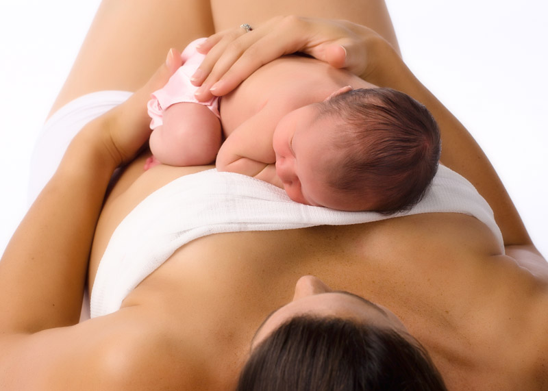 A newborn baby sleeping hon her mom's chest