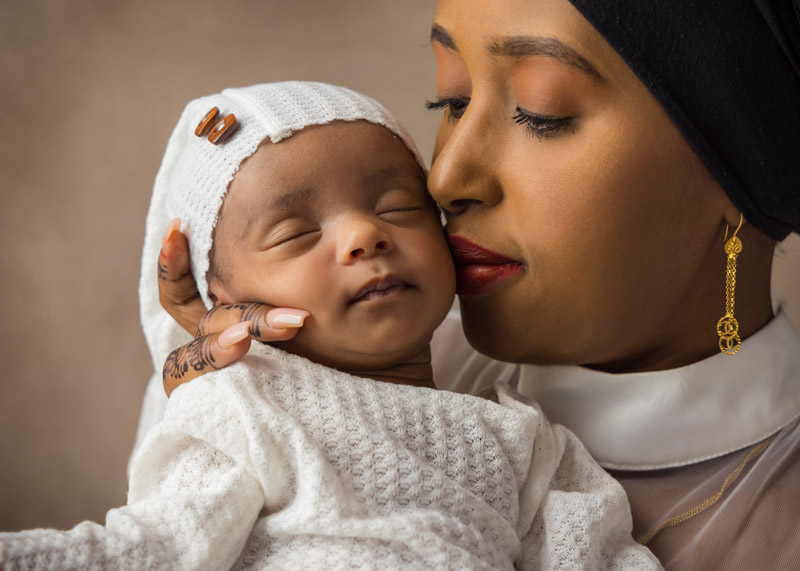 mother holds new baby close to her face